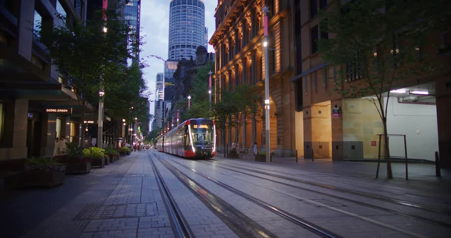 Modern train passing on an urban road surrounded by buildings