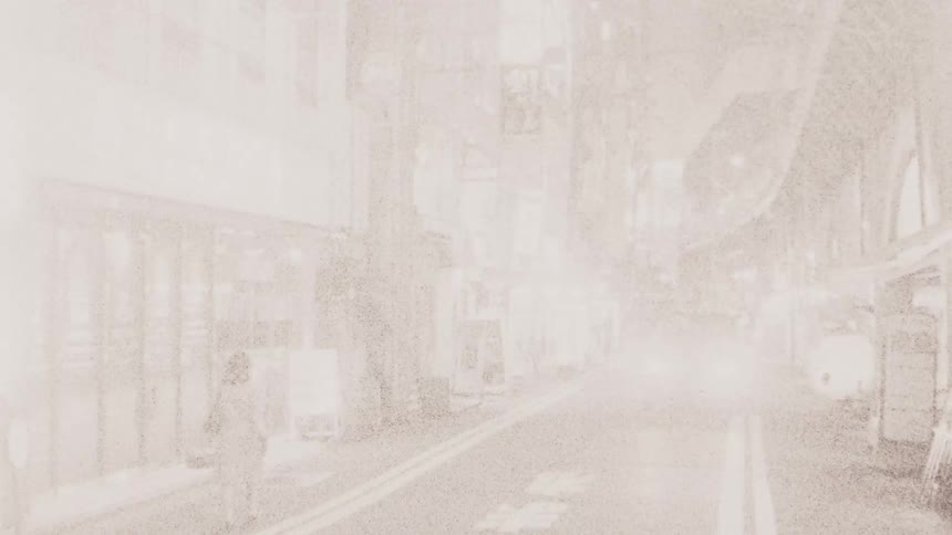 A car drives around people walking in the street