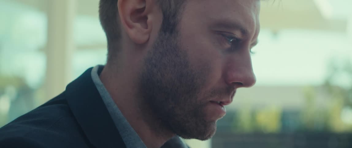 Side portrait of a bearded man wearing a blazer talking