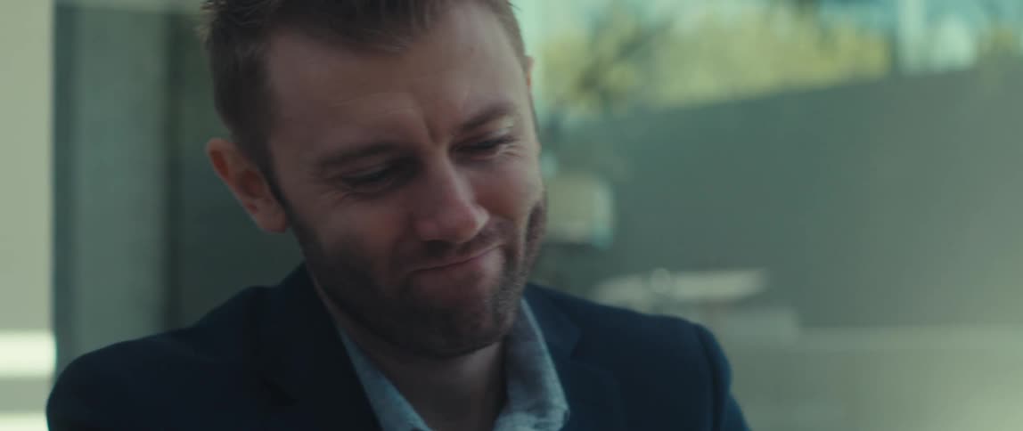 Man in dark blue blazer talking