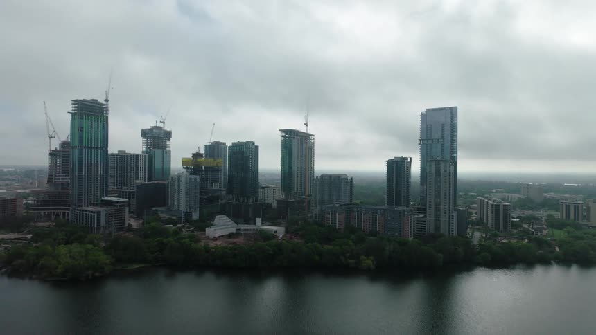 A city center with huge skyscraper buildings and there is a large water canal next to them