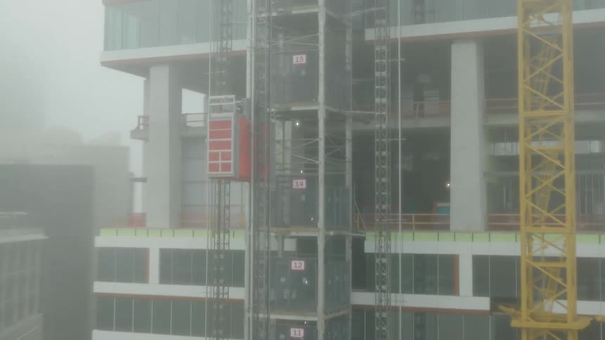 Construction site with a large yellow crane next to a building under construction