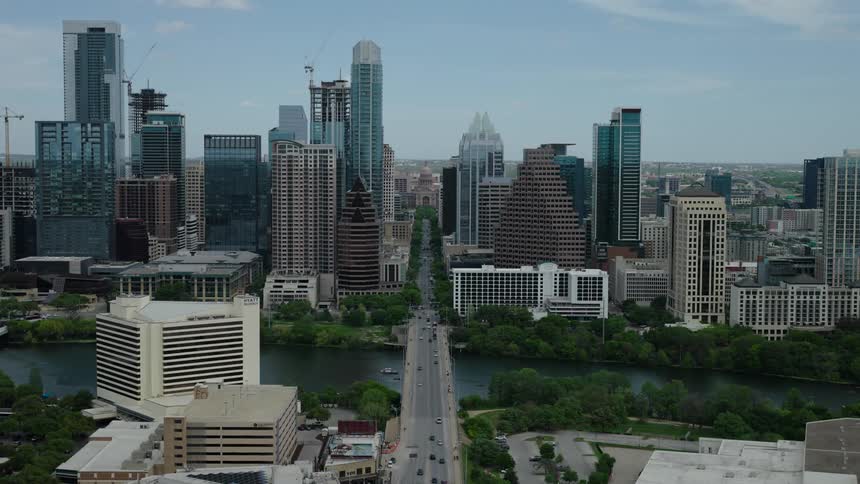 Aerial view of a bridge that crosses a sea channel and connects a metropolis with skyscrapers
