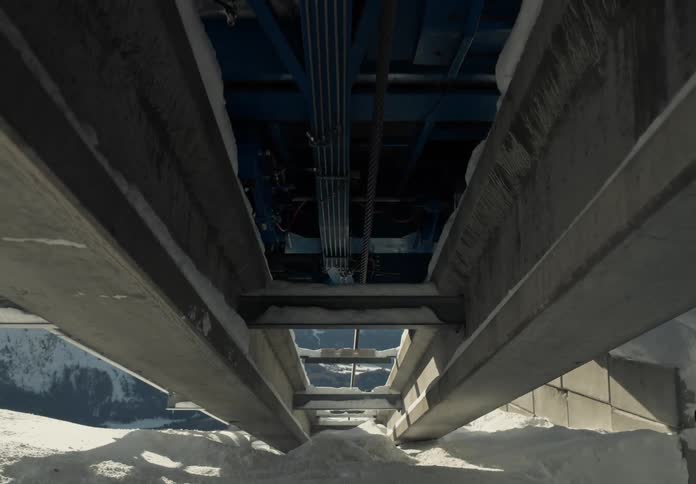 Structure of a cable car with concrete rails flanked by snow