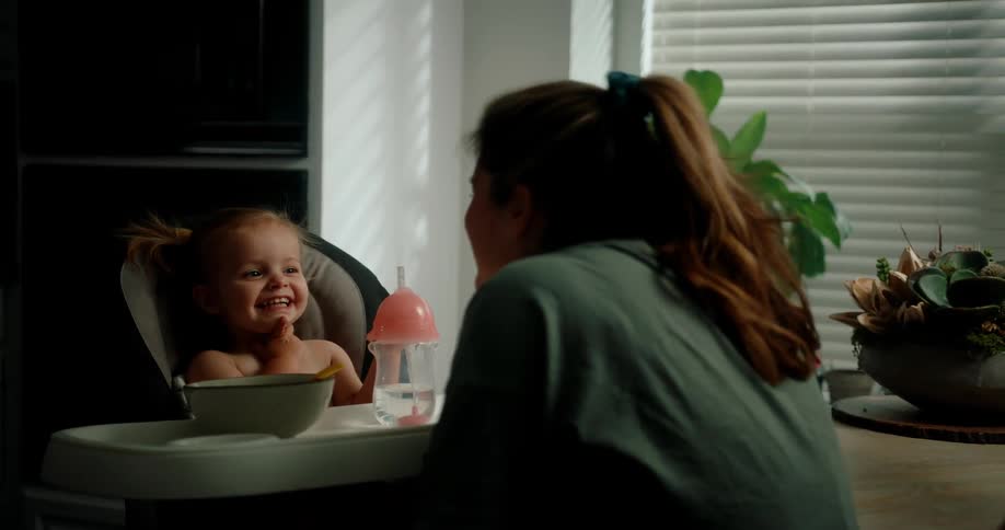 Mother interacting with her little daughter who is sitting