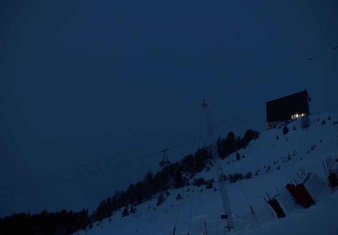 Landscape of a snowy mountain at night and a cable car in operation