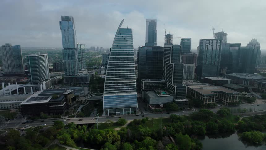 Urban landscape with several tall buildings some under construction and a green park area in the foreground