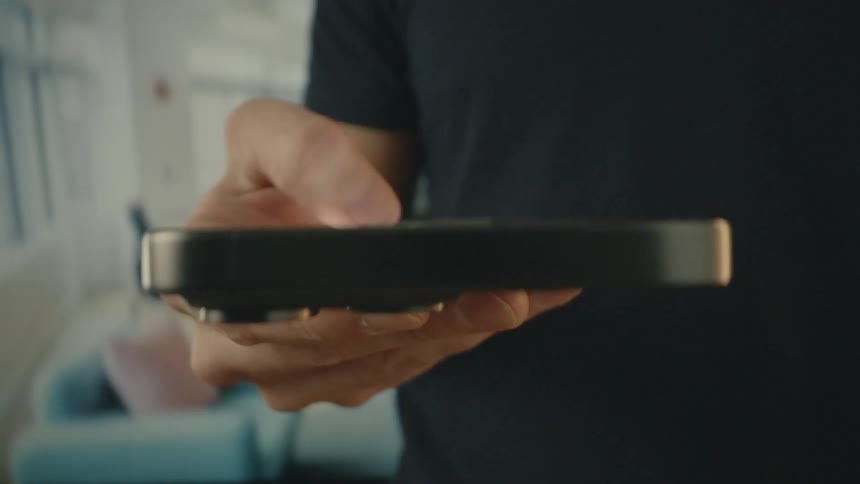 A man is tapping the screen on his cell phone