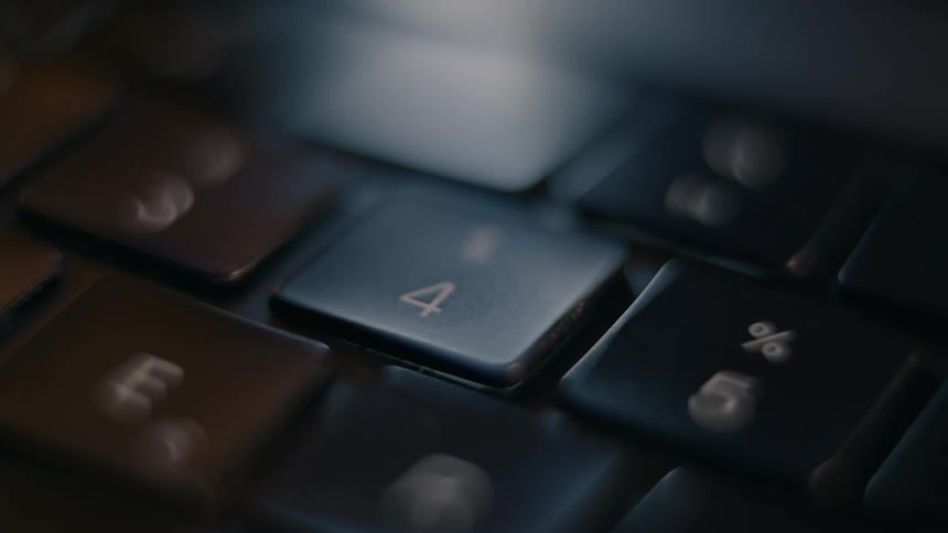 A person presses the number four key on the laptop
