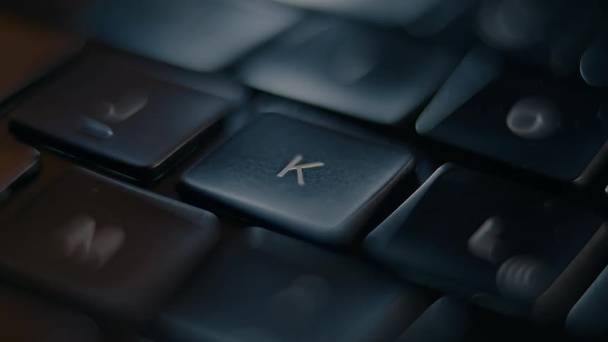 A finger pressing the k key on a keyboard