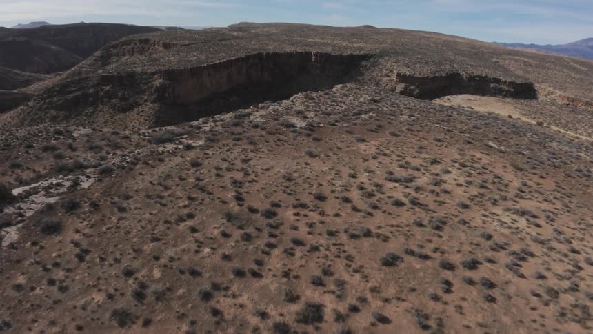 A canyon is revealed in a desert mountain landscape