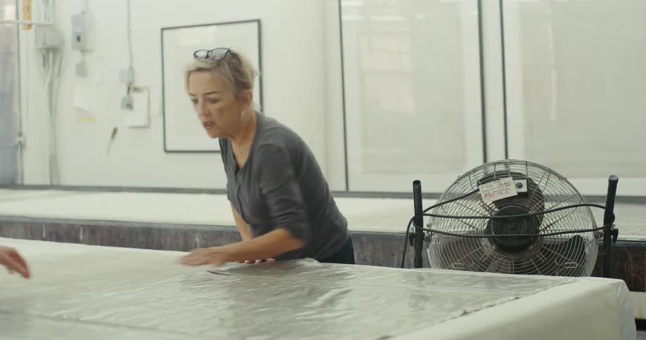 A clip of an elderly woman working in the factory