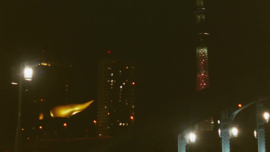 Night scene with urban lighting highlighting streetlights a building with a golden structure and a tall illuminated tower