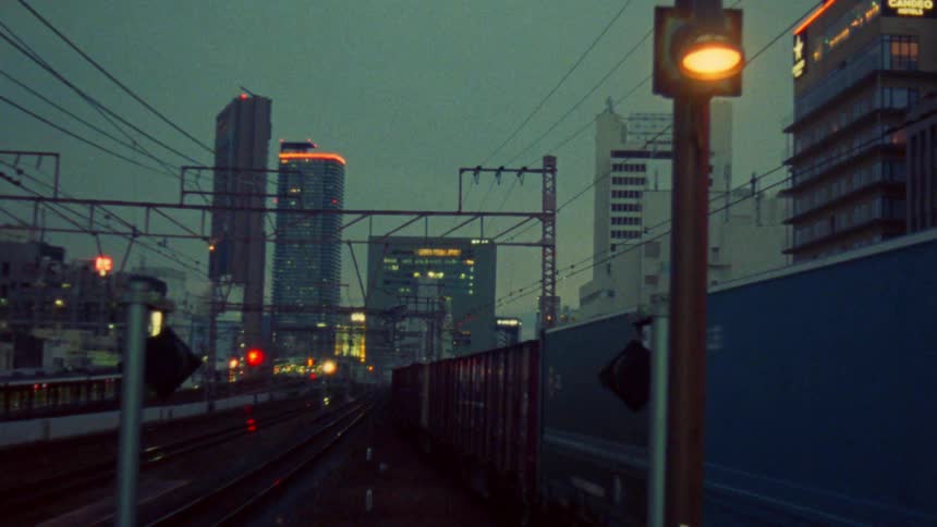 Trains driving through the city at dusk