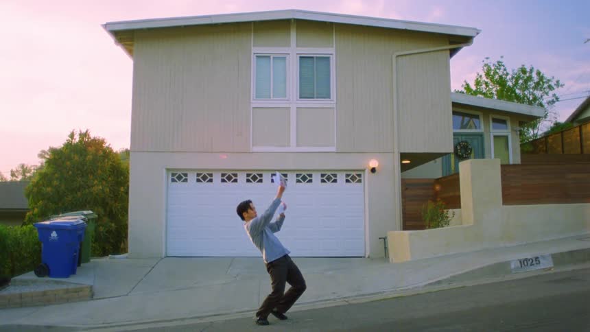 A man looks at his mail then starts stretching and dancing in the street