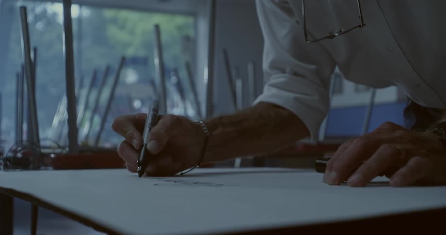 Hand of an artist with pen drawing on a whiteboard