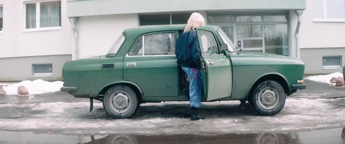 Two women get into the vehicle in front of a building