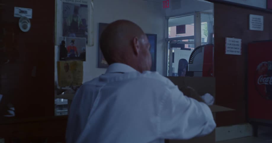 A man watches as a woman enters his restaurant
