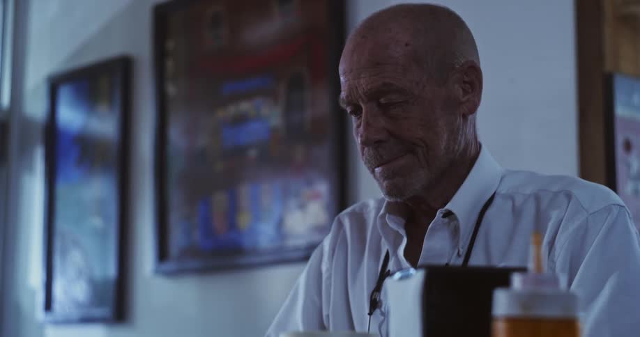 A man looks sad standing by the counter