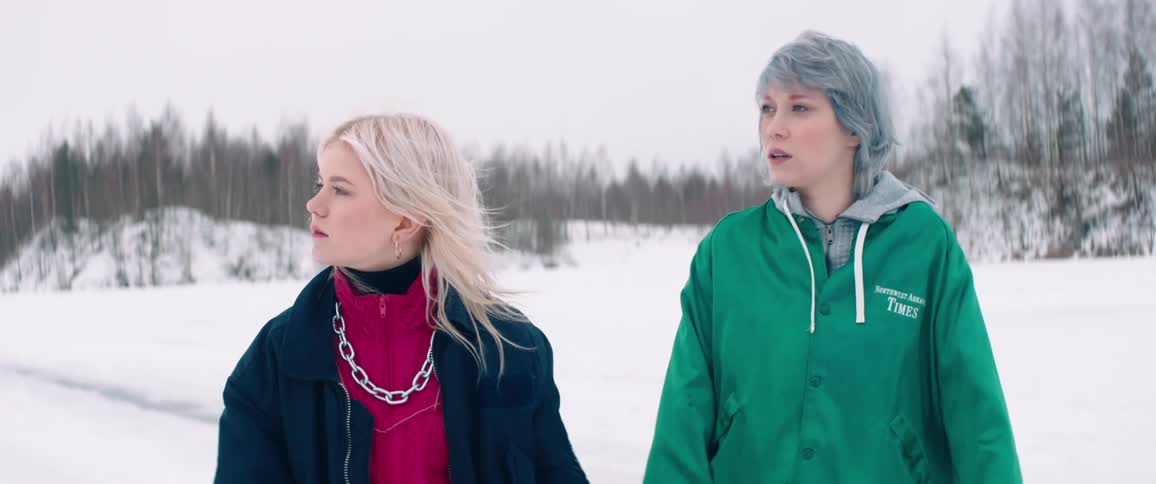 Two women walk together in the snow