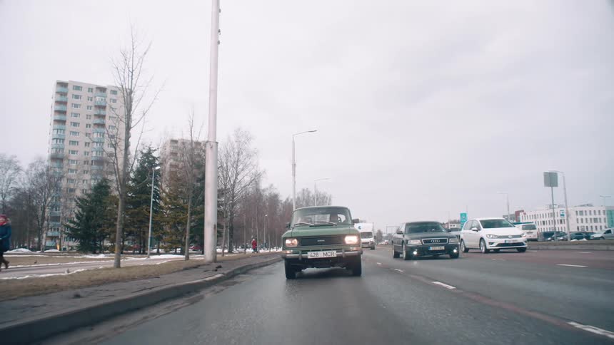 Traffic is flowing in the lanes on a cloudy day