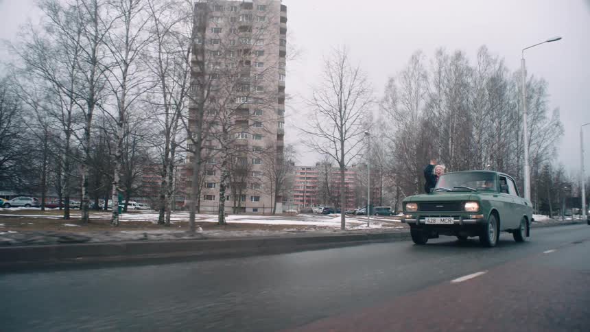 Woman having fun in a moving car with her body out the window
