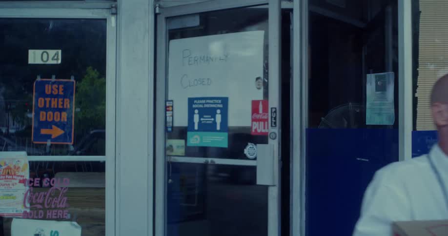 A person is carrying a large cardboard box out of a building