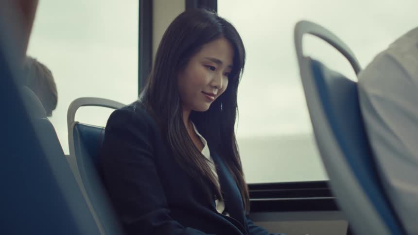 A woman smiles as she rides on the train