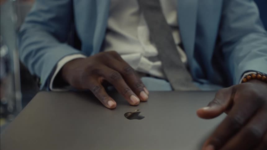 A mans hands are shown opening a laptop computer