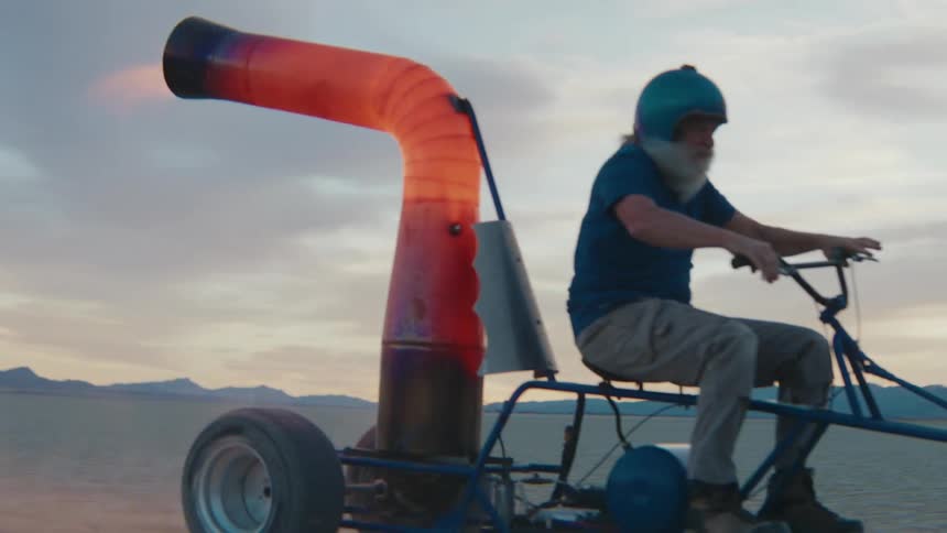 A mans off road vehicle is spitting fire from behind as he drives