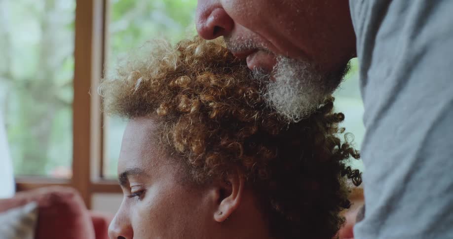 Older man with white beard leans next to younger man with curly hair