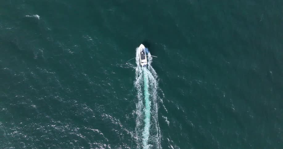 A boat cuts throug the water in an ocean