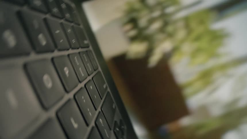 The person opens the laptop and presses a key on it