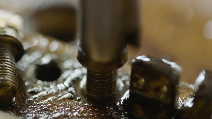 A person uses a socket and then their fingers to loosen a bolt
