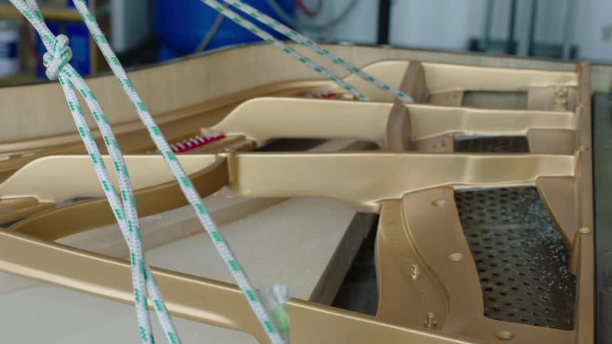 A large plastic piece is being lowered into an open wooden frame