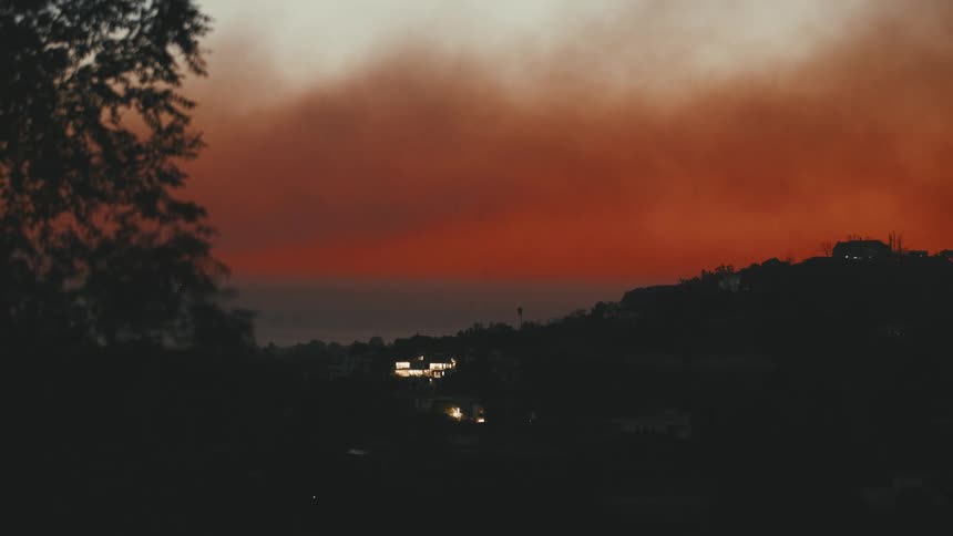 The sky is full of smoke above the hills