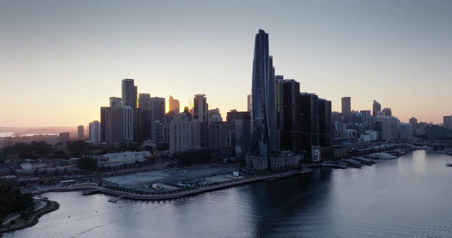 The sun is rising on the tall buildings in the city
