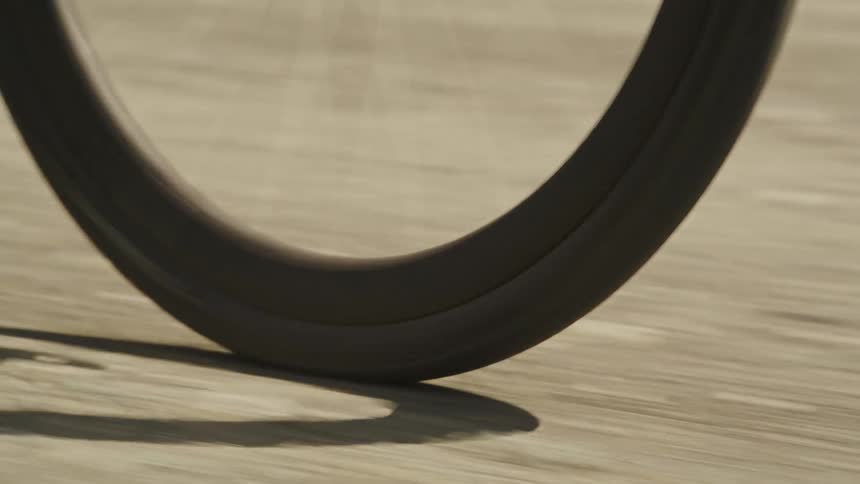 Zoom-in on a gravel bike tire rolling on a dirt path