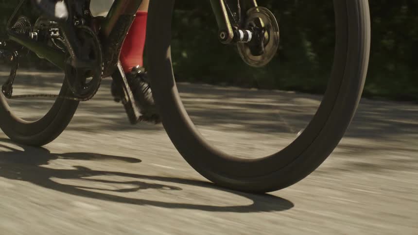 Close up on the tires of a gravel bike being ridden quickly down a dirt road