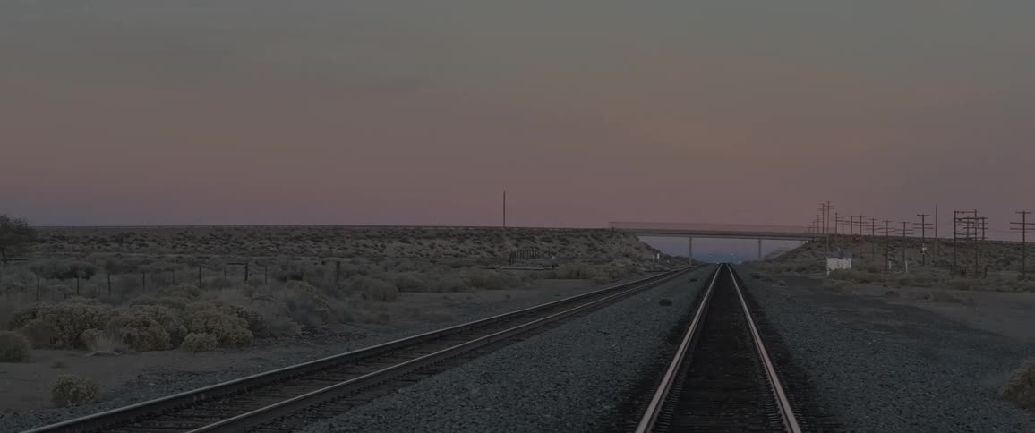 Train tracks run through the long flat field