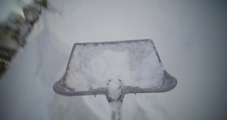 A person shoveling snow from the driveway