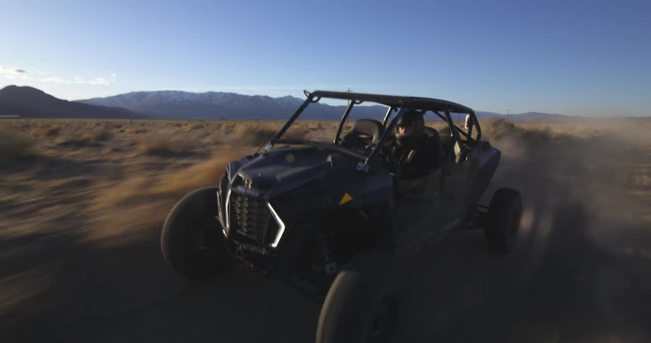 A man is driving a dune buggy through the desert