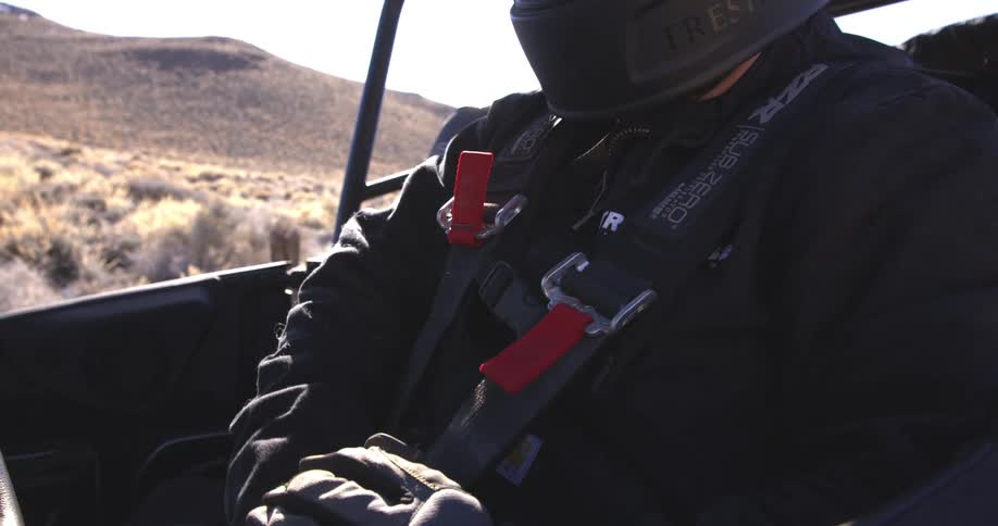 A man attaches his seatbelt in the off road vehicle