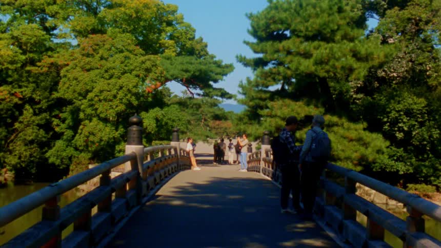 People are standing on a bridge over a river