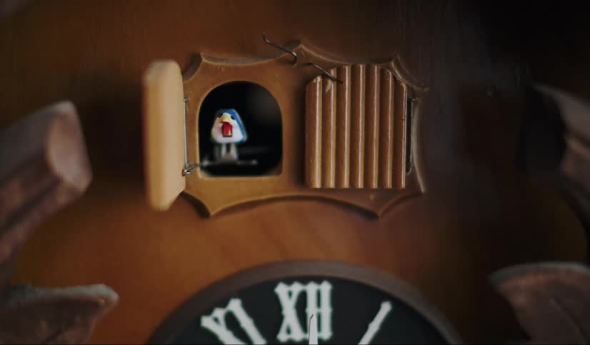 A small colorful bird pops out of a wooden cuckoo clock