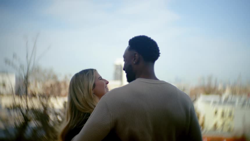 Couple outdoors looking at each other happily and hugging