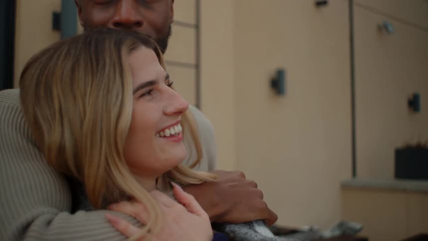 A couple are smiling and hugging