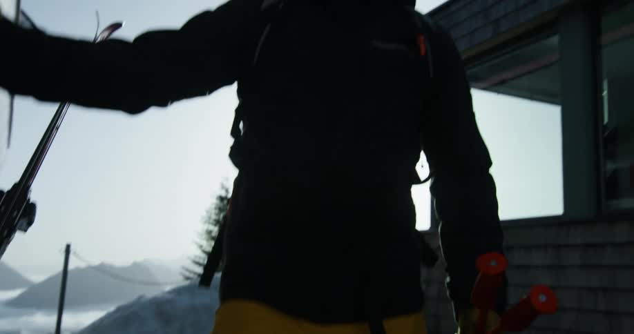 Two people in ski gear getting off a cable car in a snowy environment