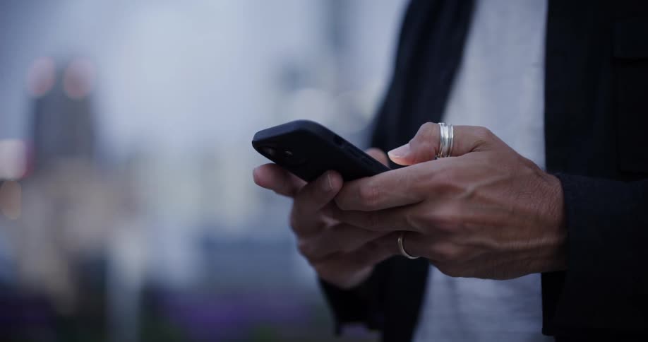 Close up of a persons hands typing on a smartphone