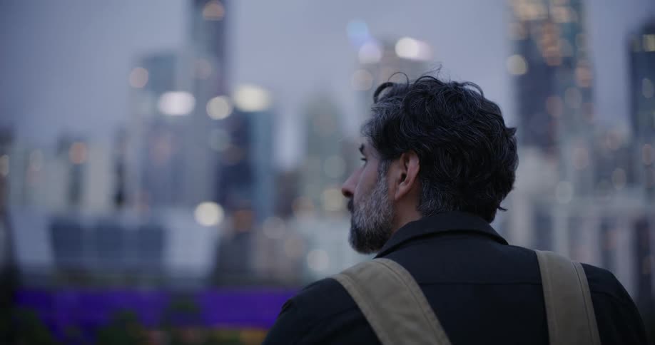 Bearded man looking at a panoramic view of skyscrapers in a metropolis